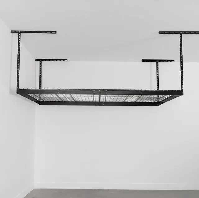 A black overhead storage is hanging from the ceiling of a garage.