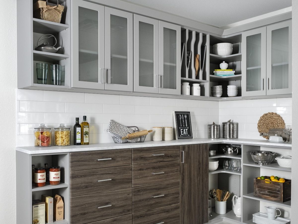 A kitchen with wooden cabinets and glass doors