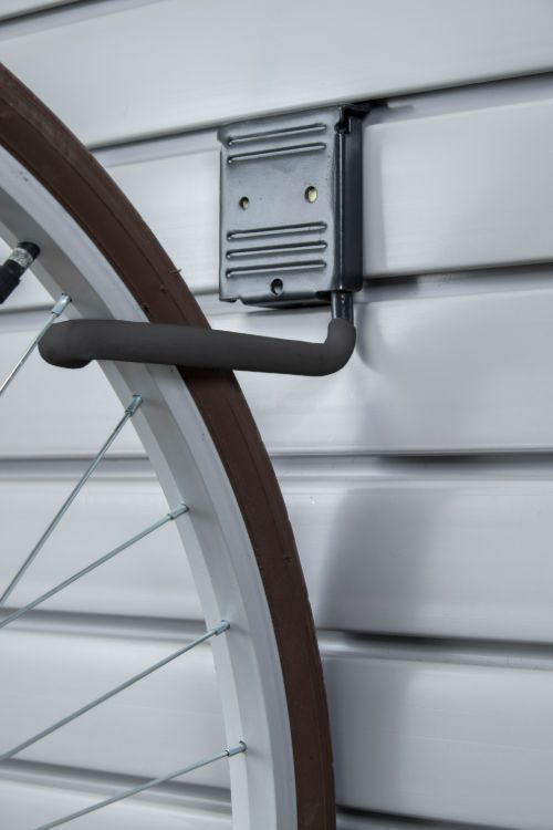 A bicycle wheel is attached to a hook on a wall