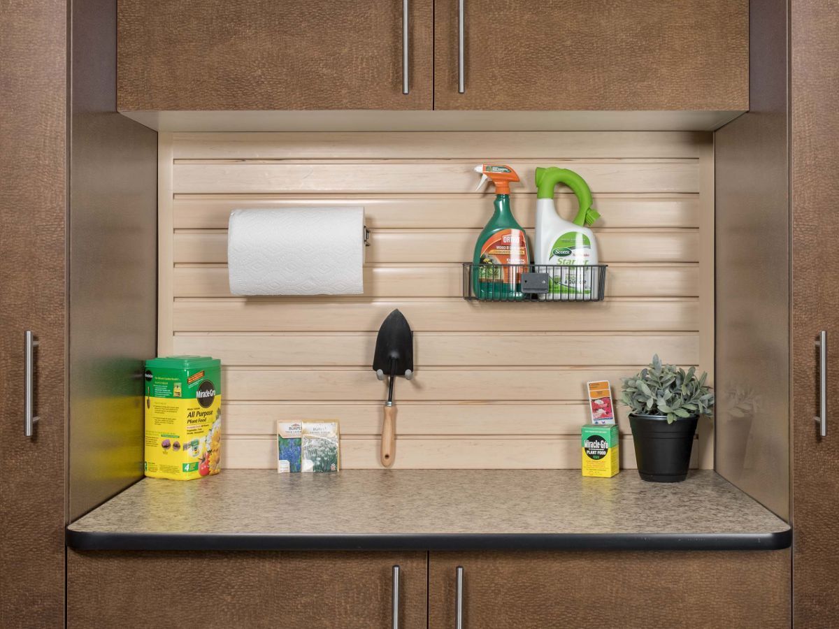 A garage workbenches with a shelf with cleaning supplies on it.