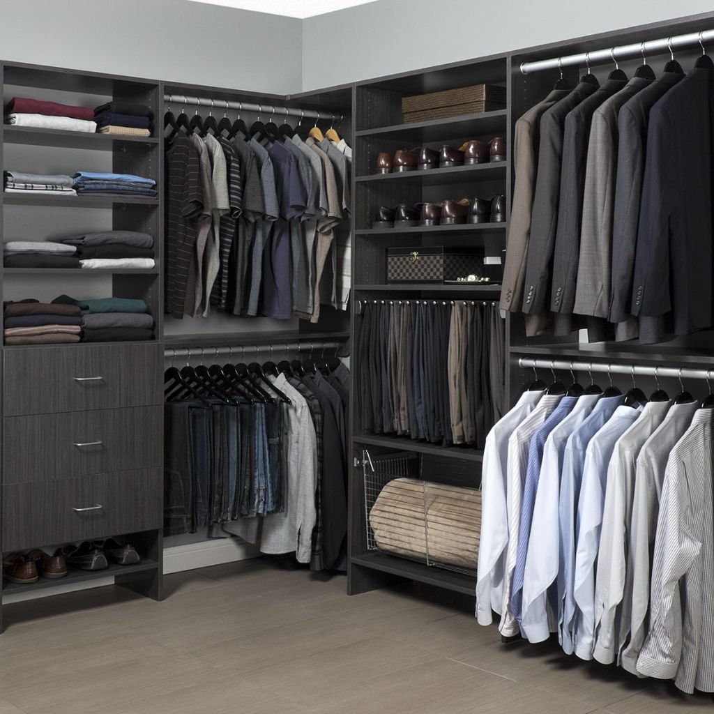 licorice flat panel walk in closets systems with lots of clothes in it.