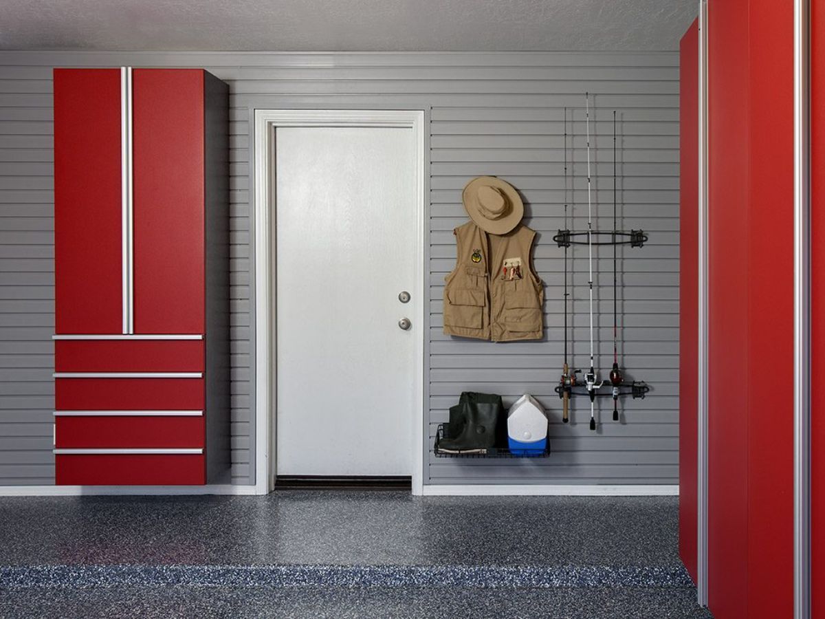 A garage with red cabinets and fishing rods hanging on the wall