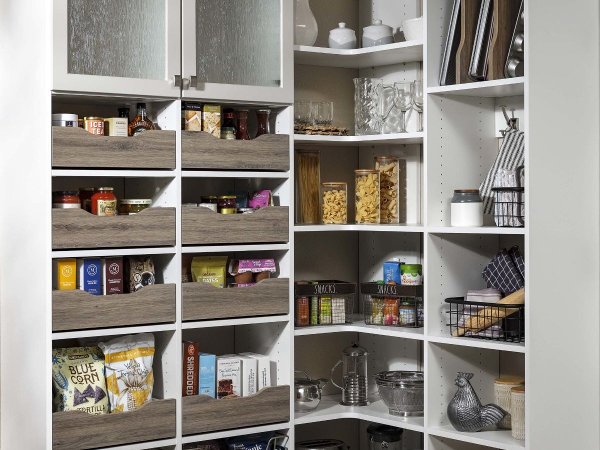 A pantry with lots of shelves and drawers filled with food.
