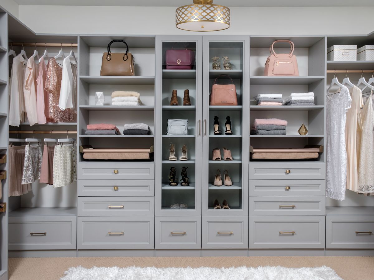 A walk in closet filled with lots of clothes and shoes.