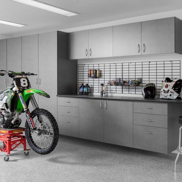 A green dirt bike with the number 8 on the front is parked in a garage.