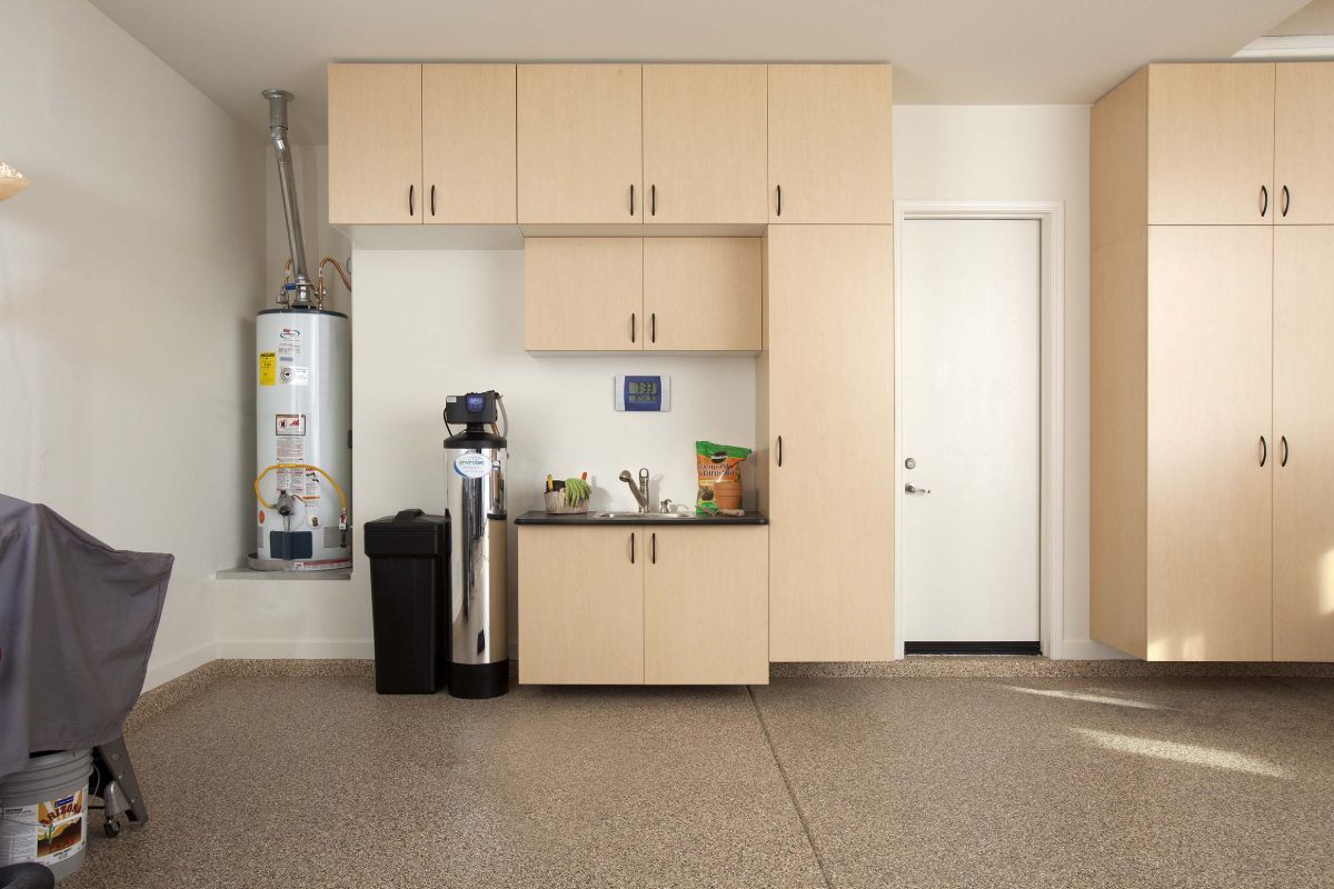 A garage with lots of cabinets and a water heater