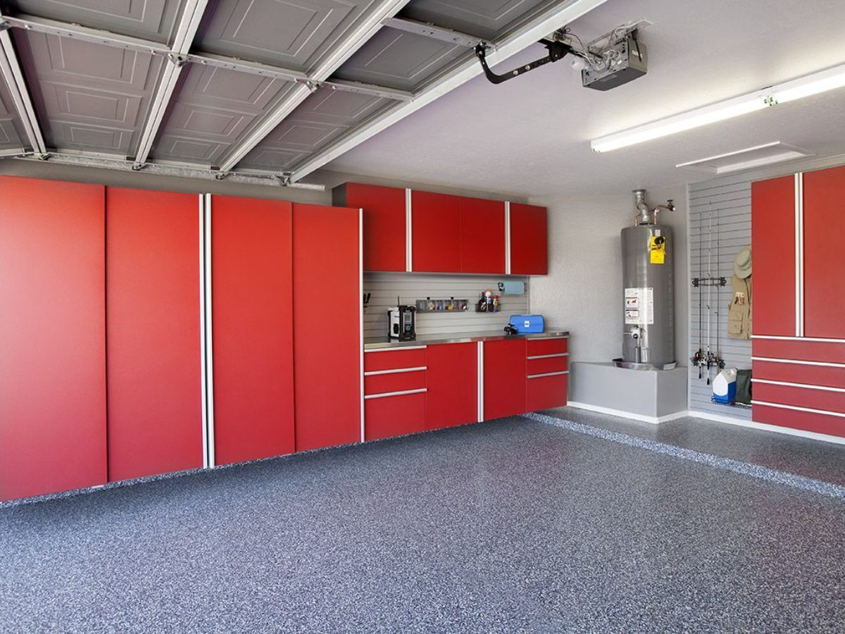 A garage with red cabinets and a water heater.