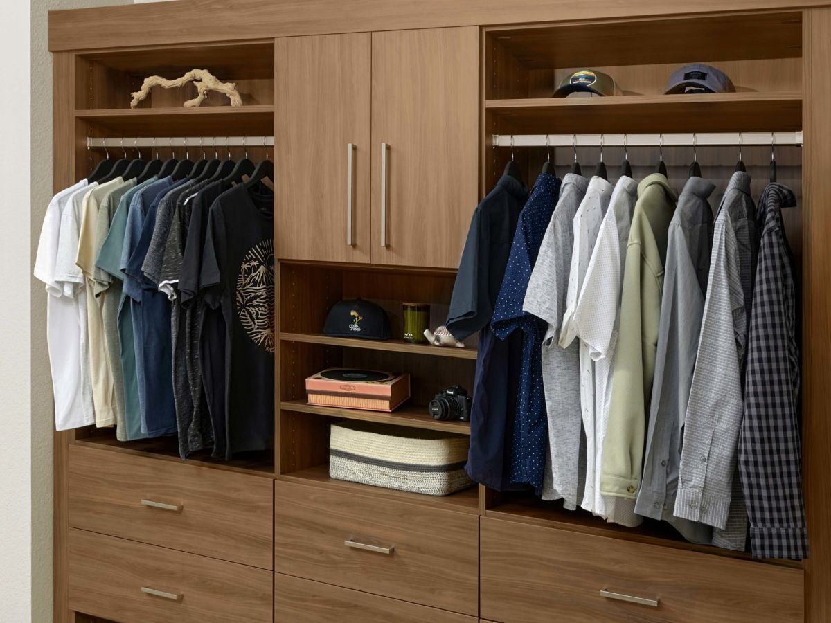 A reach in closet filled with lots of clothes and shoes.