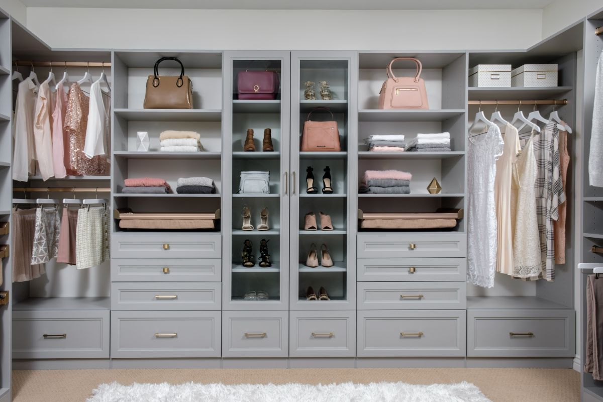 A walk in closet filled with lots of clothes and shoes.