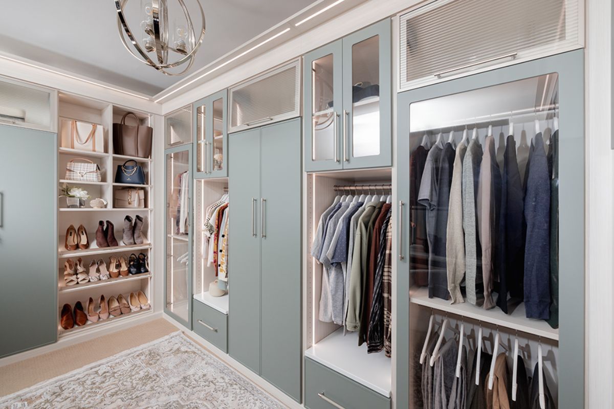 A walk in closet filled with lots of clothes and shoes.