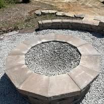 Octagonal fire pit with stone blocks filled with gray gravel.