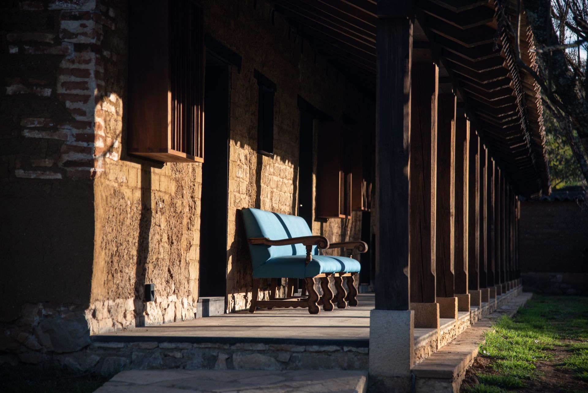 A porch with a bench and chairs on it