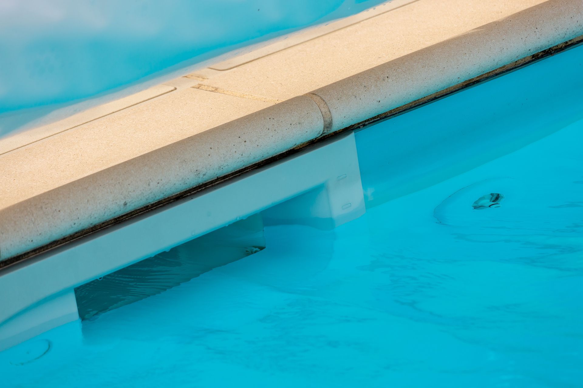 A swimming pool with a white railing and blue water.