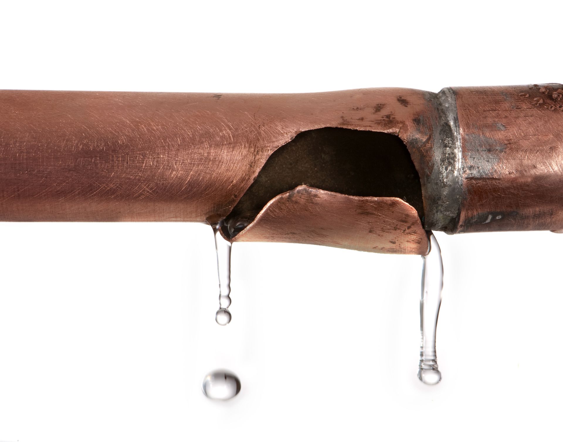 A broken copper pipe with water dripping from it on a white background.