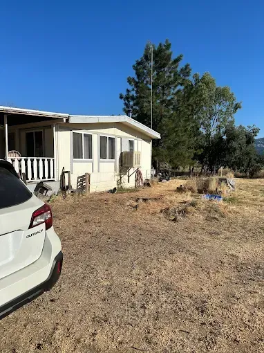 A white car is parked in front of a house.