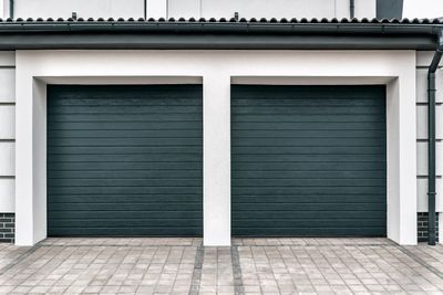 Twin Blue Green Garage Door — House And Driveway in Appleton, WI