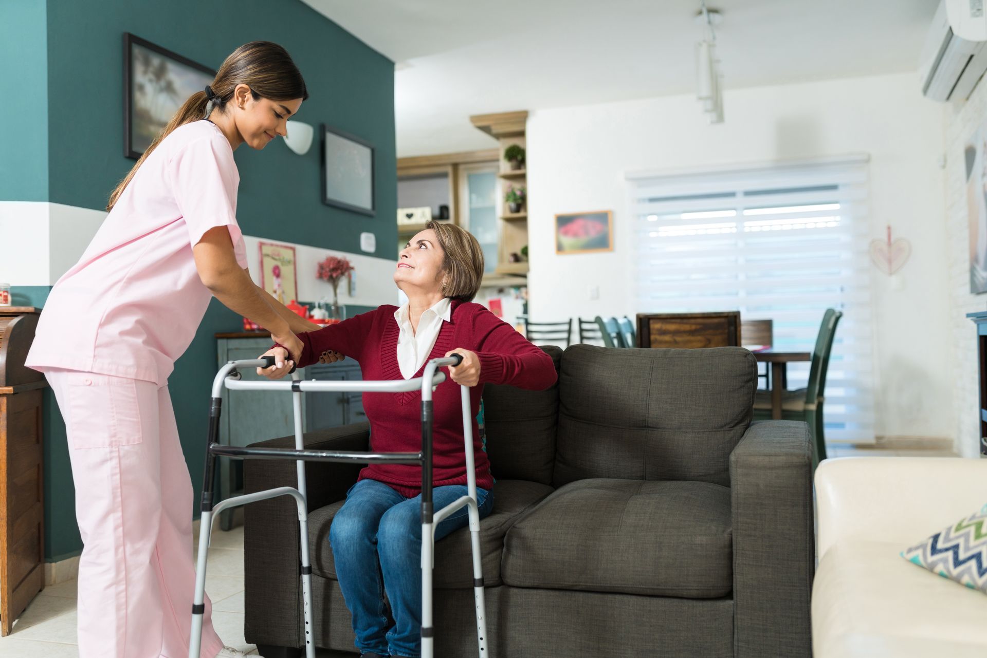 A caregiver is helping an elderly woman to sit.