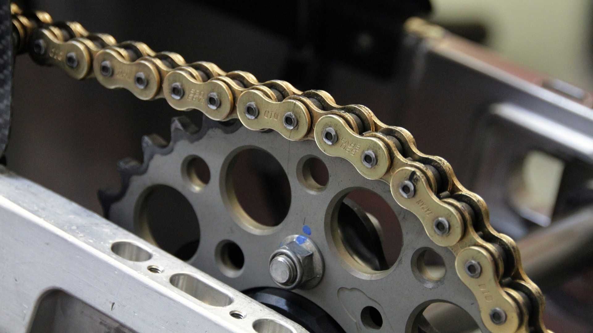 A close up of a motorcycle chain and sprocket
