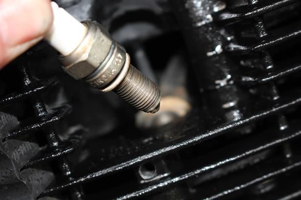 A close up of a person holding a spark plug