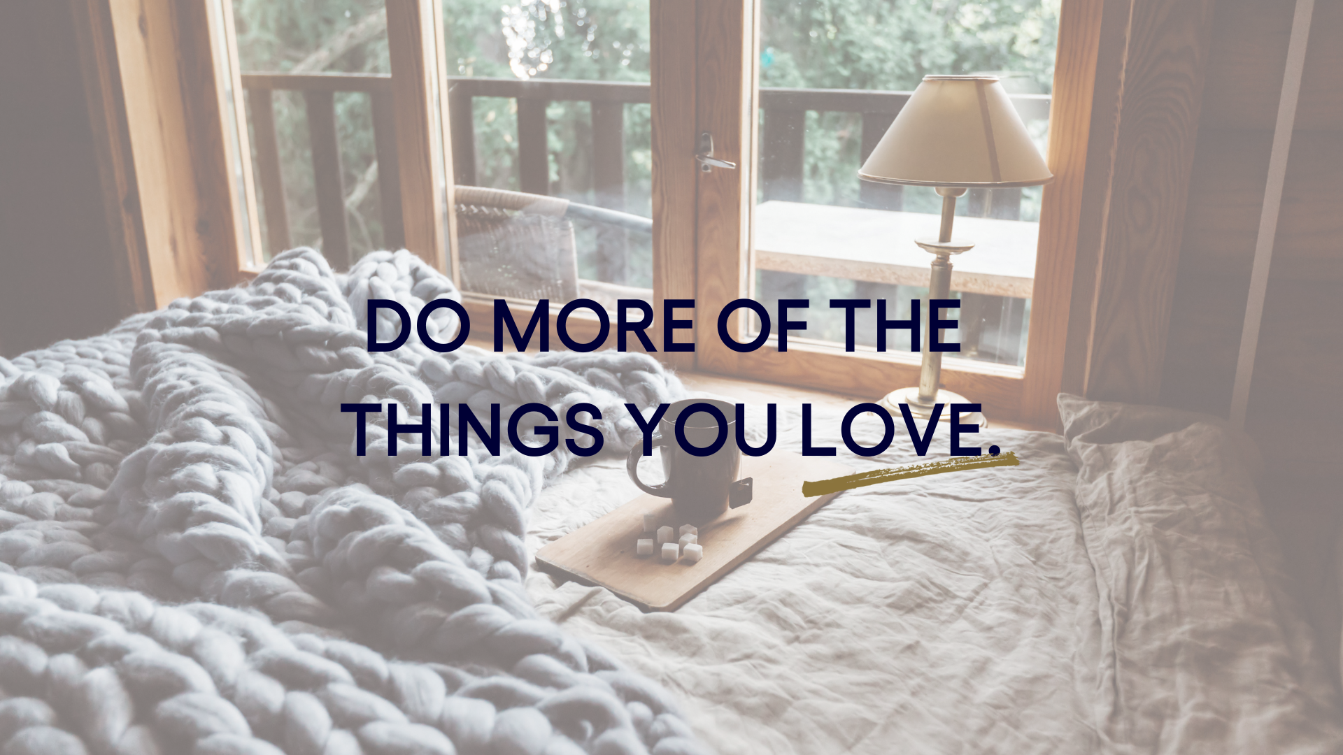 A bed with a blanket and a lamp in a room with a quote that says `` do more of the things you love ''.