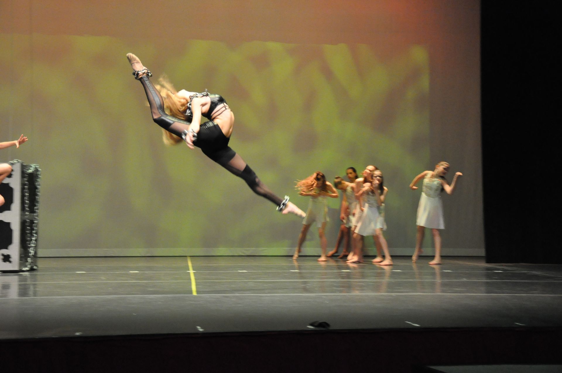 Pastelle performing onstage doing a split leap
