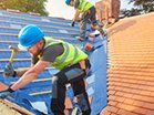 a group of construction workers are working on a roof .