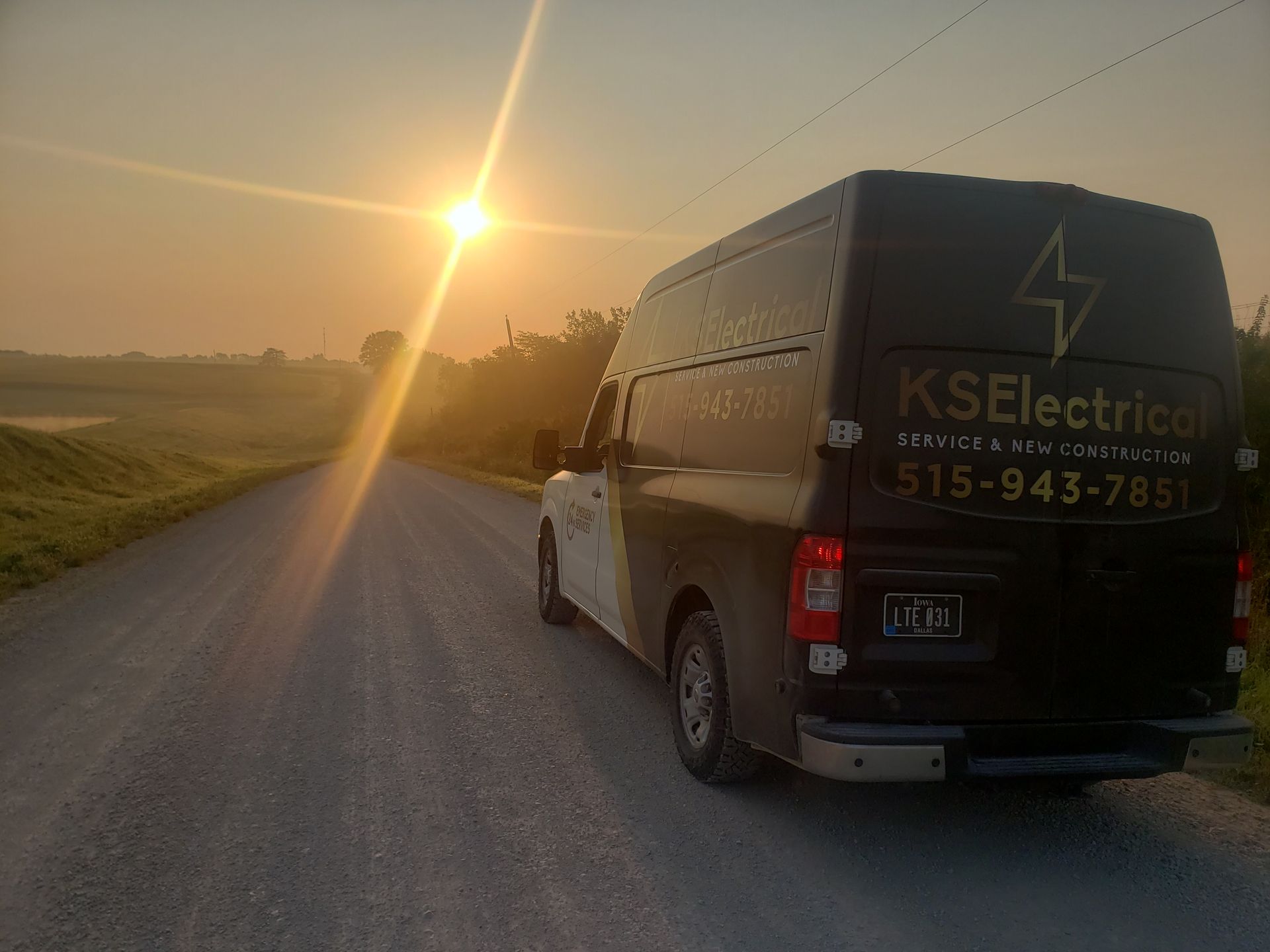 A van is parked on the side of a dirt road at sunset.