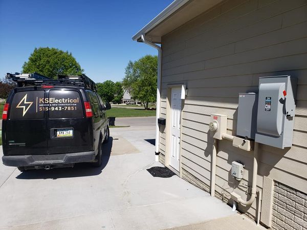 A van that says k2 electrical is parked in front of a house