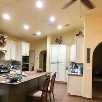 A kitchen with a large island and a ceiling fan.