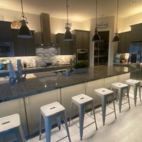 A kitchen with stools and a long counter top.