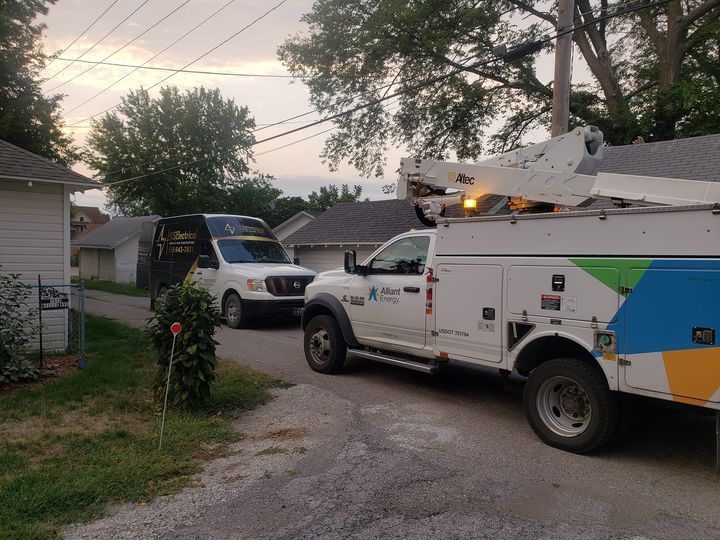 Two utility trucks are parked on the side of the road.