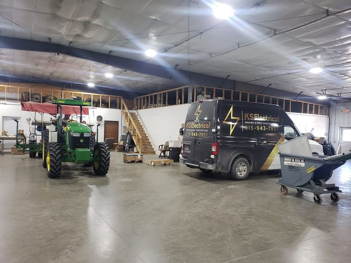 A tractor and a van are parked in a warehouse.