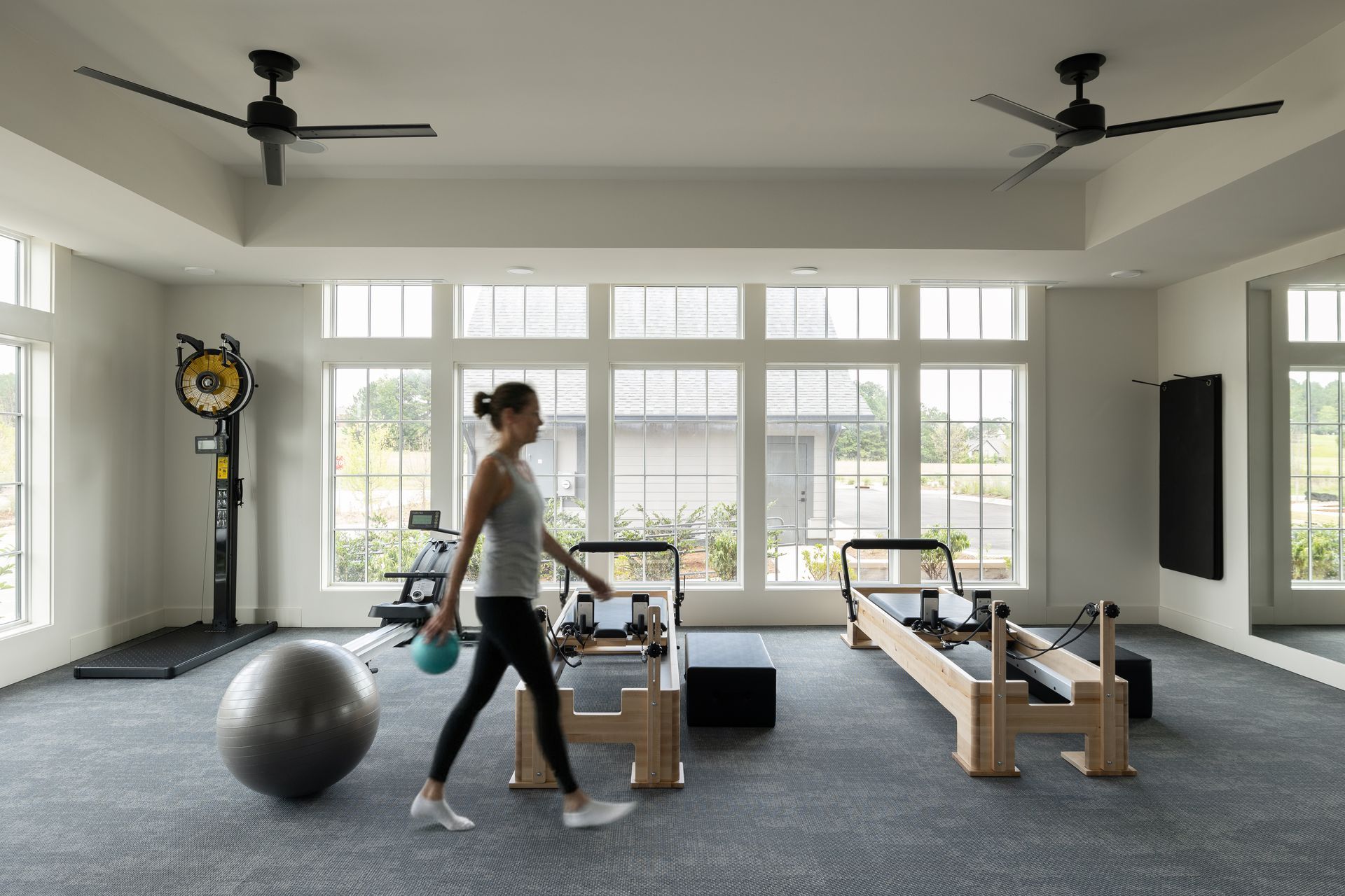 Gym interior with exercise equipment and two people working out.