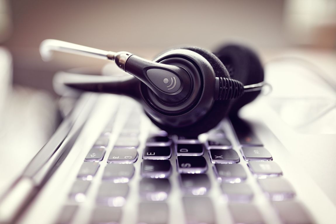 A headset is sitting on top of a laptop keyboard.