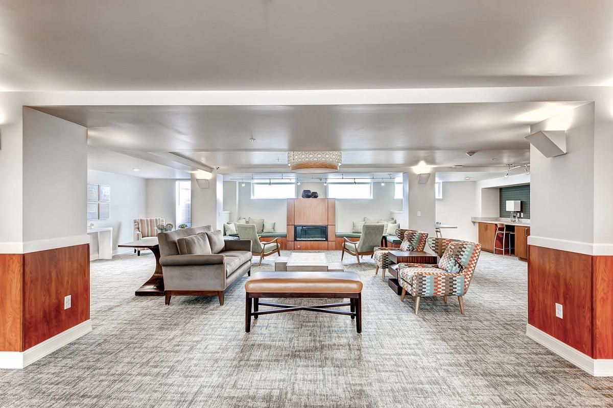 Spacious living room with seating areas, fireplace, and light-colored carpet.