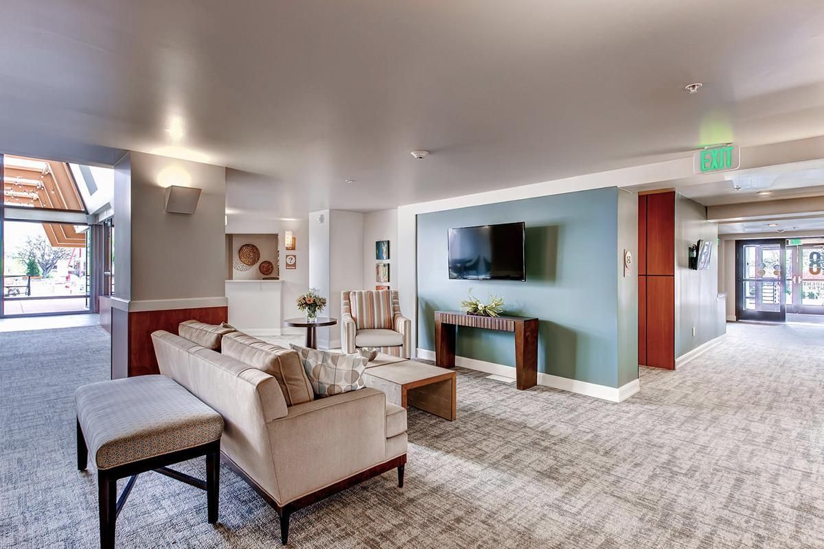 A modern, open-concept living area with seating, a TV, and access to an outside space.