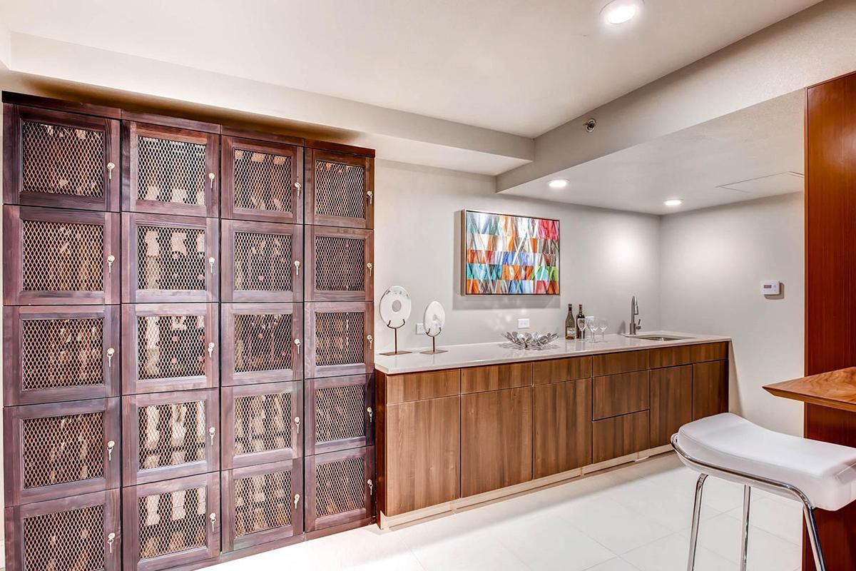A room with wooden cabinets, a bar, and decorative wall panels; a painting hangs on the wall.
