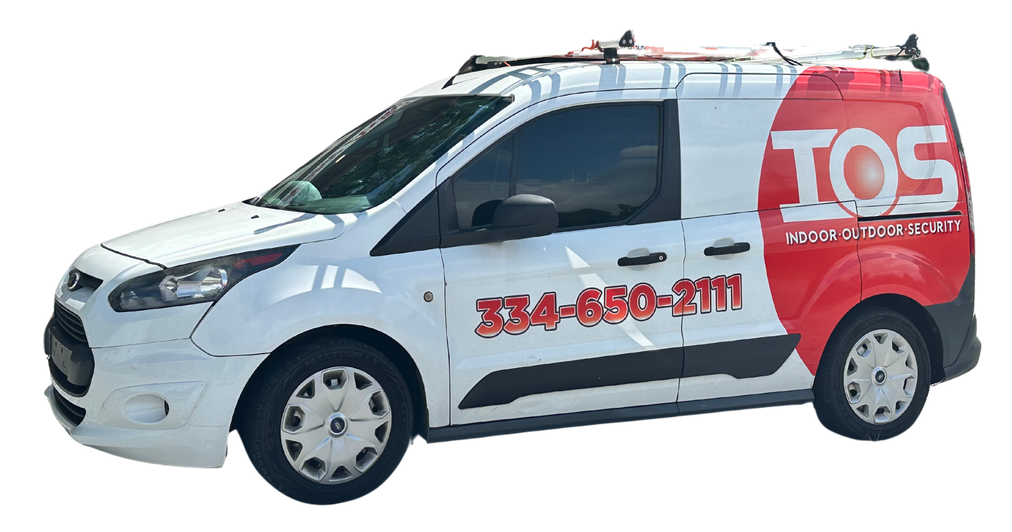 A white van in Auburn Al with the word indoor outdoor security on the side is parked on a white background.