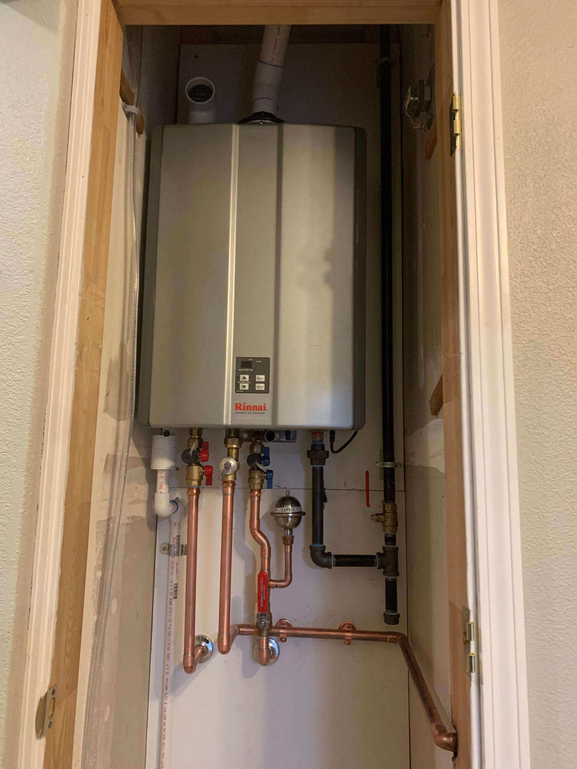 Rightway Plumbing Sewer And Drain - A water heater is installed in a closet next to copper pipes.