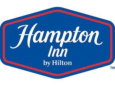 The Hampton Inn by Hilton logo: blue hexagon with red border, containing the brand name in white script and serif text.