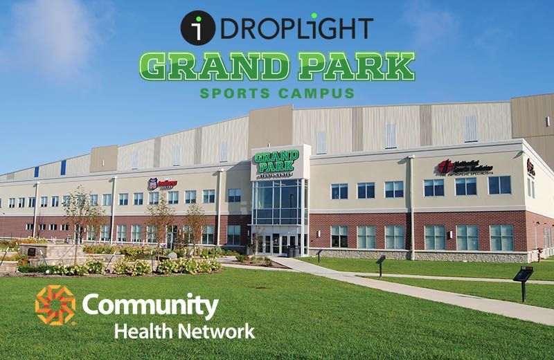 The Hampton Inn by Hilton logo: blue hexagon with red border, containing the brand name in white script and serif text.