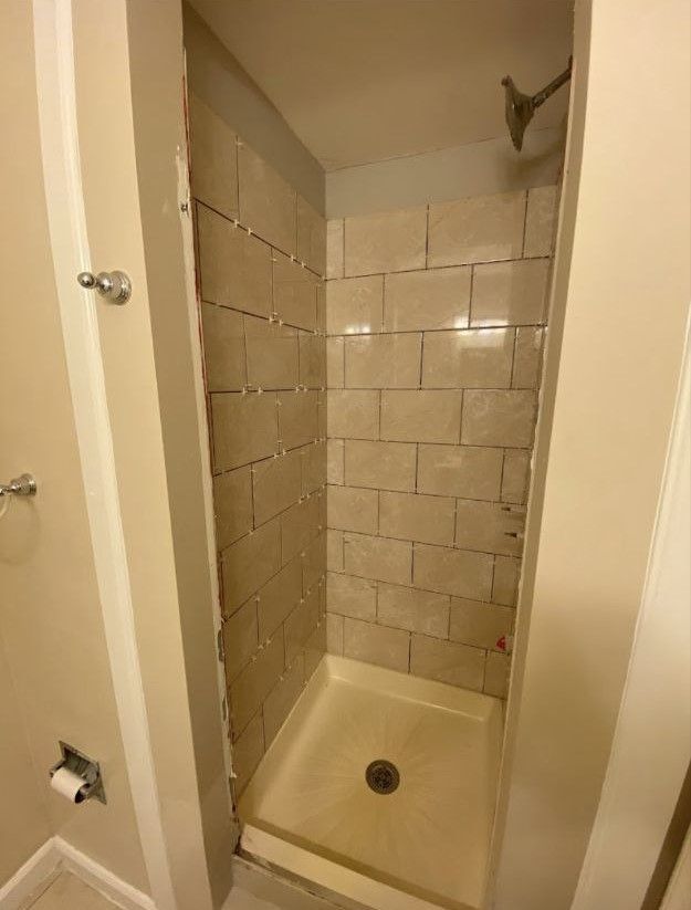 A bathroom with a walk in shower and a toilet.
