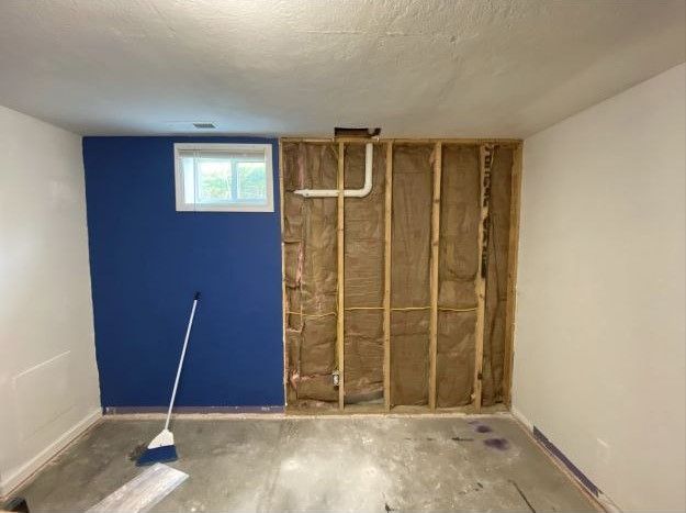 A room with a blue wall and a broom on the floor