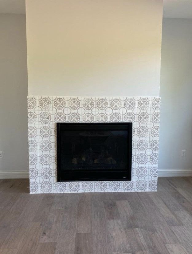 An empty living room with a fireplace in the middle