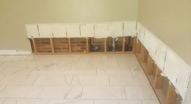 A room with a brick wall and a tile floor.