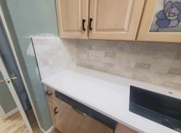A kitchen with wooden cabinets and a white counter top.