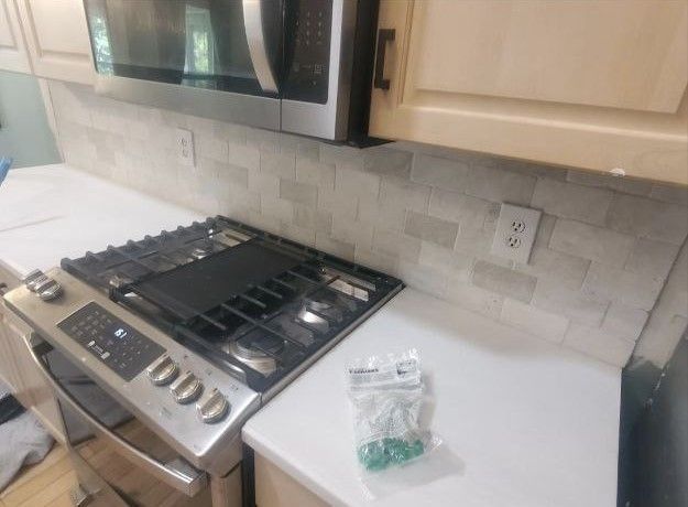 A kitchen with a stove top oven and a microwave.