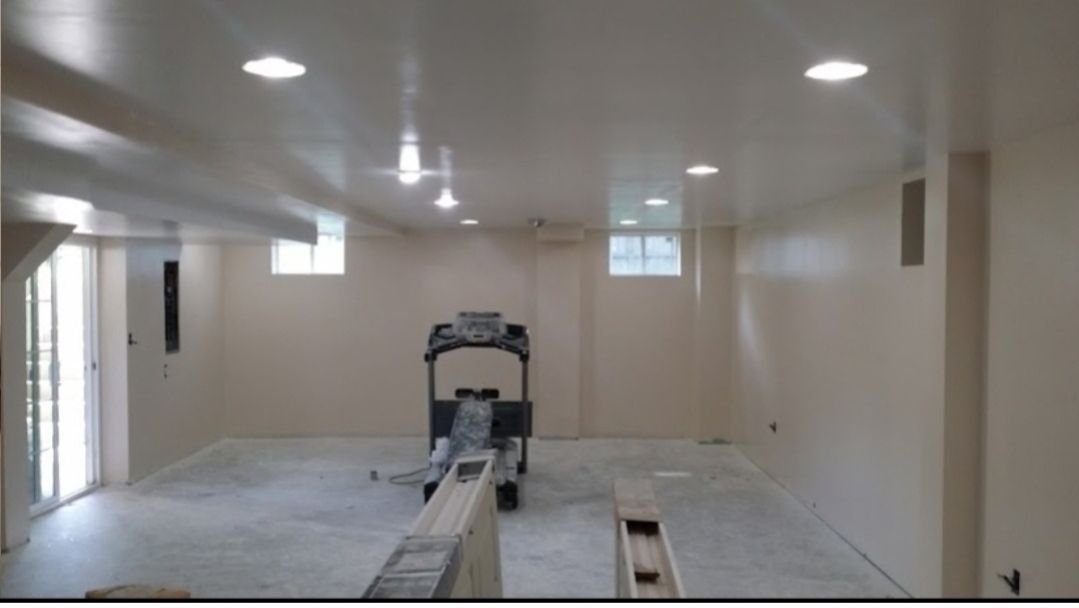 An empty basement with a treadmill in it