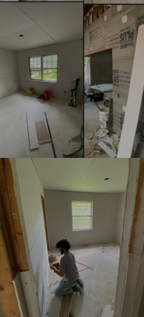 A man is working on a wall in a room.