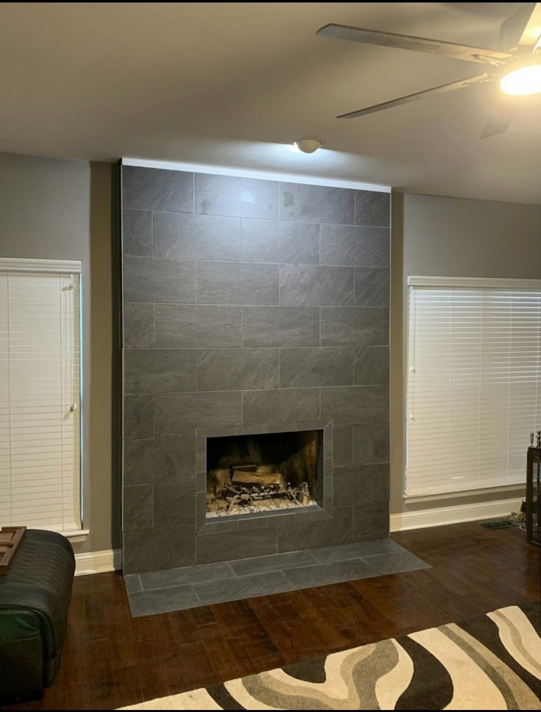 A living room with a fireplace and a rug